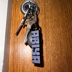 May include: A set of keys with a purple keychain that says "PASSION" hanging on a door knob.