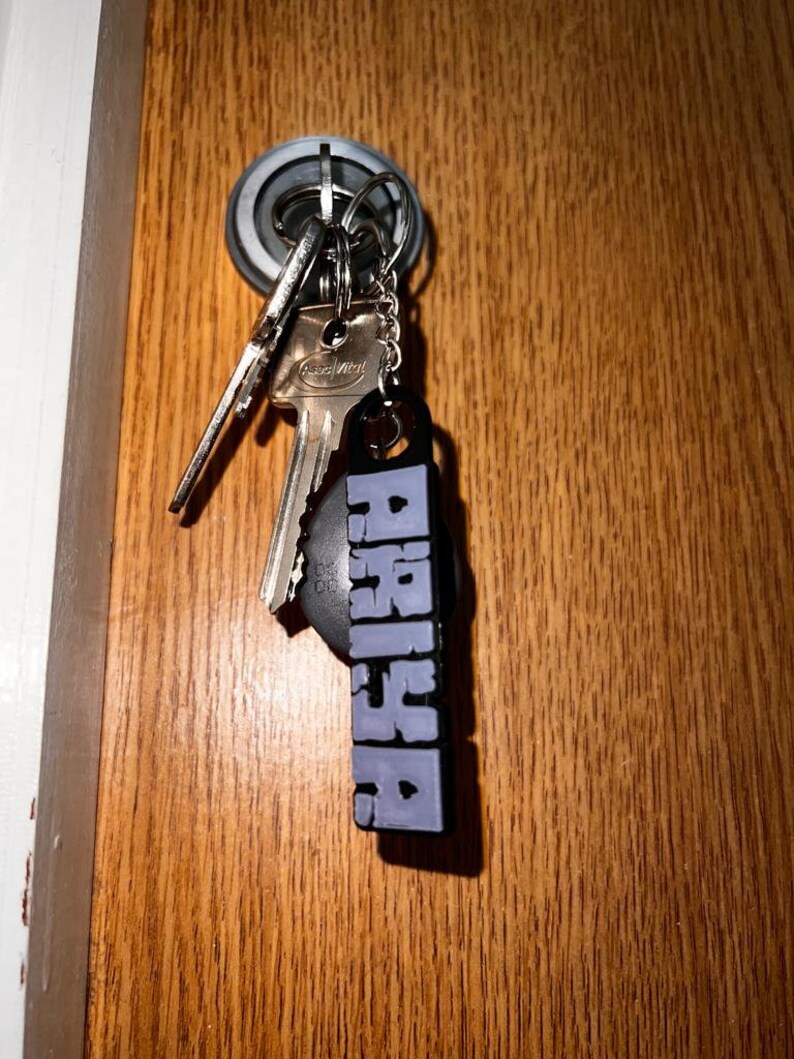 May include: A set of keys with a purple keychain that says "PASSION" hanging on a door knob.