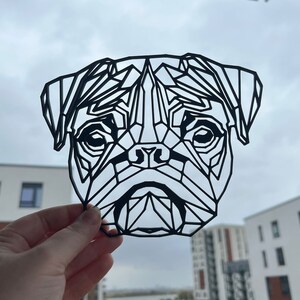 May include: Black and white geometric design of a pug dog's face. The design is made of many triangles and lines, creating a modern and abstract look.