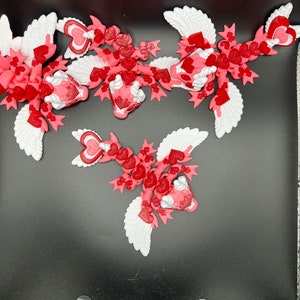 Puede incluir: Tres adornos de coraz&oacute;n alados de color rosa y blanco con un dise&ntilde;o de coraz&oacute;n. Los adornos est&aacute;n hechos de un material suave y flexible y son perfectos para las decoraciones del D&iacute;a de San Valent&iacute;n.