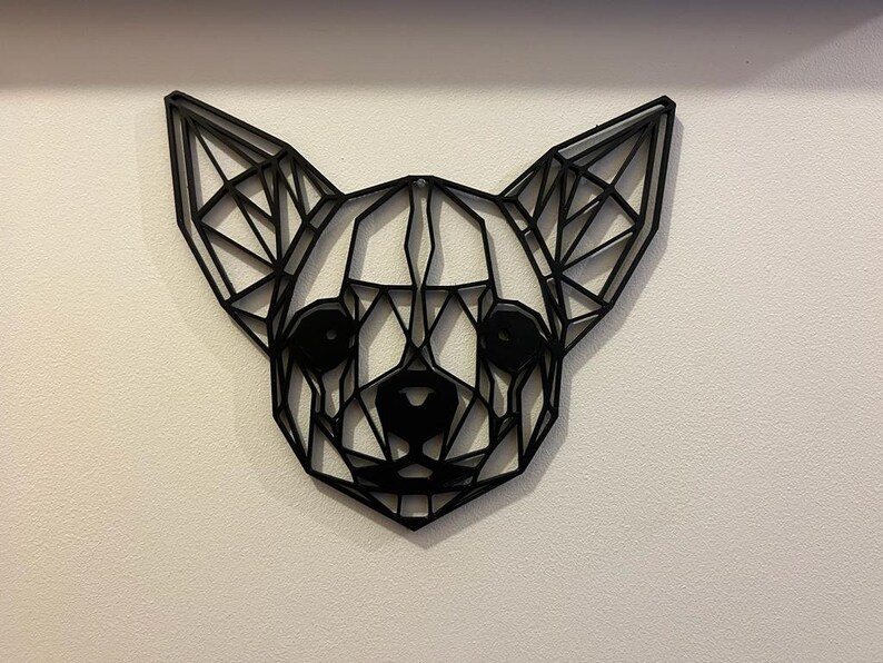 May include: Black geometric wall art of a chihuahua's head. The art is made of thin metal and is in a low-poly style.