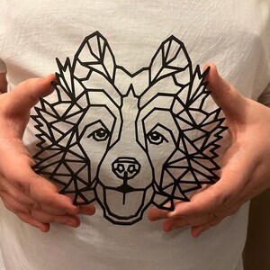 Puede incluir: Un dise&ntilde;o de lobo geom&eacute;trico negro en una camiseta blanca.