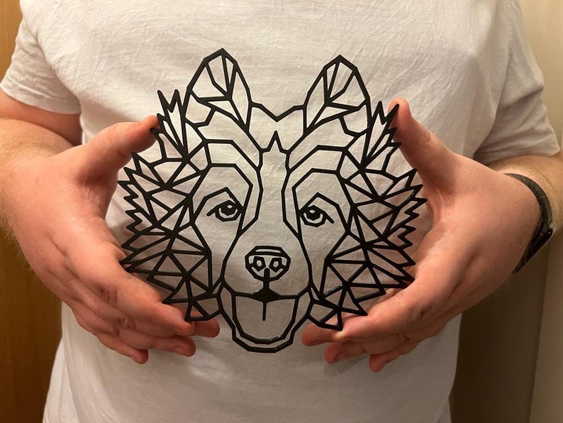 Puede incluir: Un dise&ntilde;o de lobo geom&eacute;trico negro en una camiseta blanca.