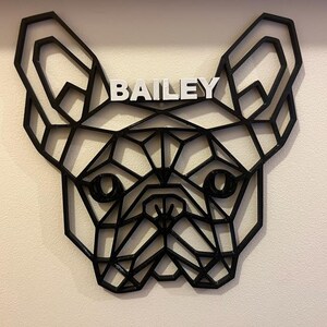 May include: Black geometric silhouette of a French Bulldog head with the name "BAILEY" written in white letters above the dog's head.