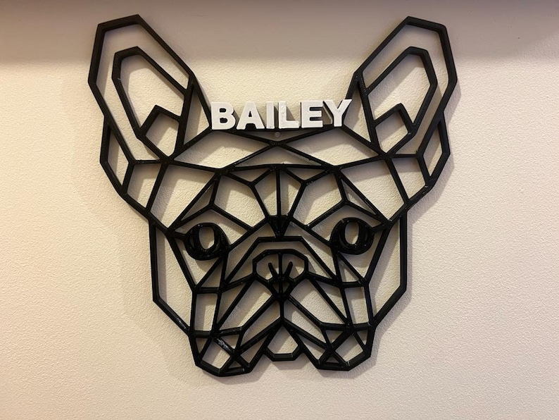May include: Black geometric silhouette of a French Bulldog head with the name "BAILEY" written in white letters above the dog's head.