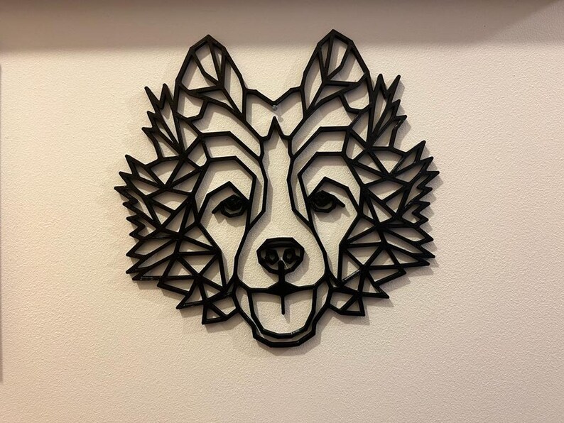 Puede incluir: Decoraci&oacute;n de pared de cabeza de lobo geom&eacute;trico negro. La cabeza de lobo est&aacute; hecha de una serie de tri&aacute;ngulos que crean un efecto 3D.