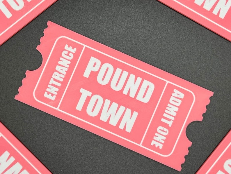 Puede incluir: Un boleto rosa con texto blanco que dice "Entrance", "Pound Town" y "Admit One".