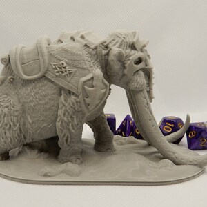 May include: A gray, 3D printed miniature of a mammoth with a saddle and armor. The mammoth has a long trunk and tusks. The miniature is posed standing on a base with four purple dice.