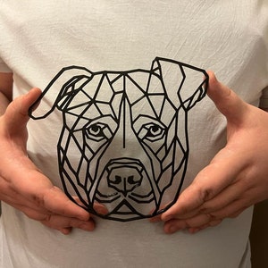 May include: A black and white geometric design of a dog's head, with a triangular pattern, on a white t-shirt.