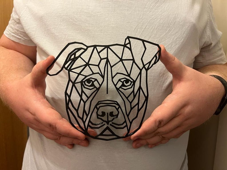 May include: A black and white geometric design of a dog's head, with a triangular pattern, on a white t-shirt.