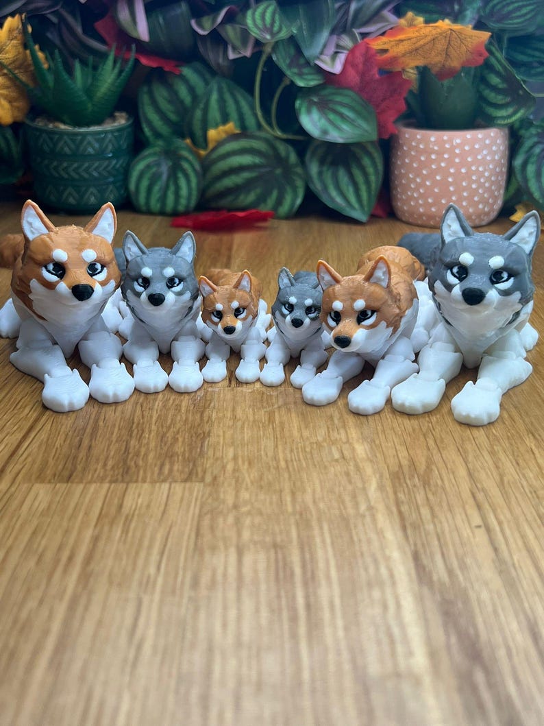Peut inclure: Un ensemble de cinq figurines de loup de diff&eacute;rentes tailles. Les figurines sont en plastique blanc avec des d&eacute;tails peints. Les loups sont dans diff&eacute;rentes poses, y compris assis, debout et couch&eacute;s. Les loups regardent tous dans des directions diff&eacute;rentes. Les figurines sont dispos&eacute;es en ligne sur une surface en bois.
