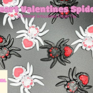 Puede incluir: Un conjunto de seis juguetes de araña articulados impresos en 3D. Tres arañas son negras con corazones rojos y tres arañas son blancas con corazones rosas. Las arañas están todas en una variedad de poses. El texto "Heart Valentines Spider" y "3D Printed Articulated Fidget Toy" es visible en la imagen. El texto "Fat Girl Makes" también es visible en la imagen.