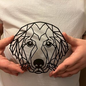 Pu&ograve; includere: Un design geometrico in bianco e nero di un muso di cane su una maglietta bianca.