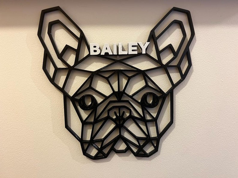 May include: Black geometric silhouette of a French Bulldog head with the name "BAILEY" written in white letters above the dog's head.