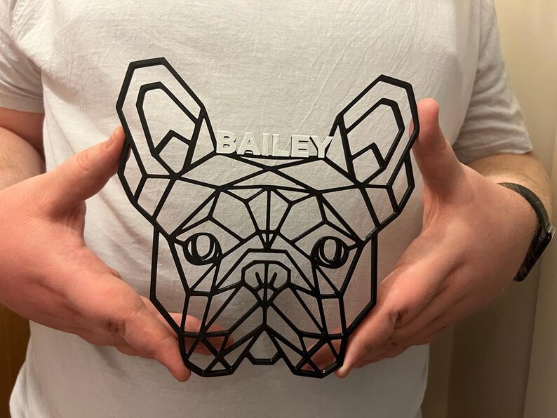May include: A black geometric design of a French Bulldog head with the name "BAILEY" written in white letters above the dog's head.