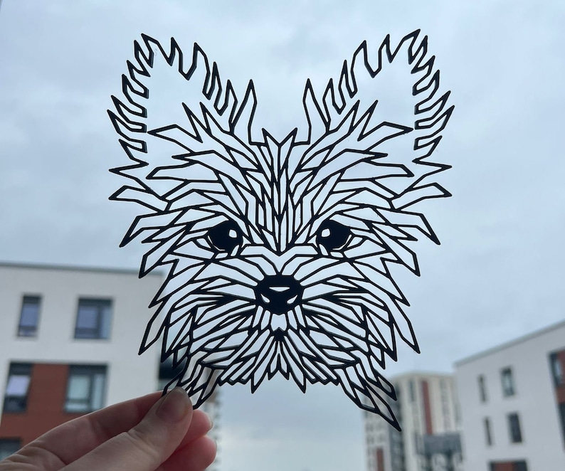 May include: Black paper cut-out of a Yorkshire Terrier dog with a geometric design. The dog's fur is made up of many small triangles and squares.