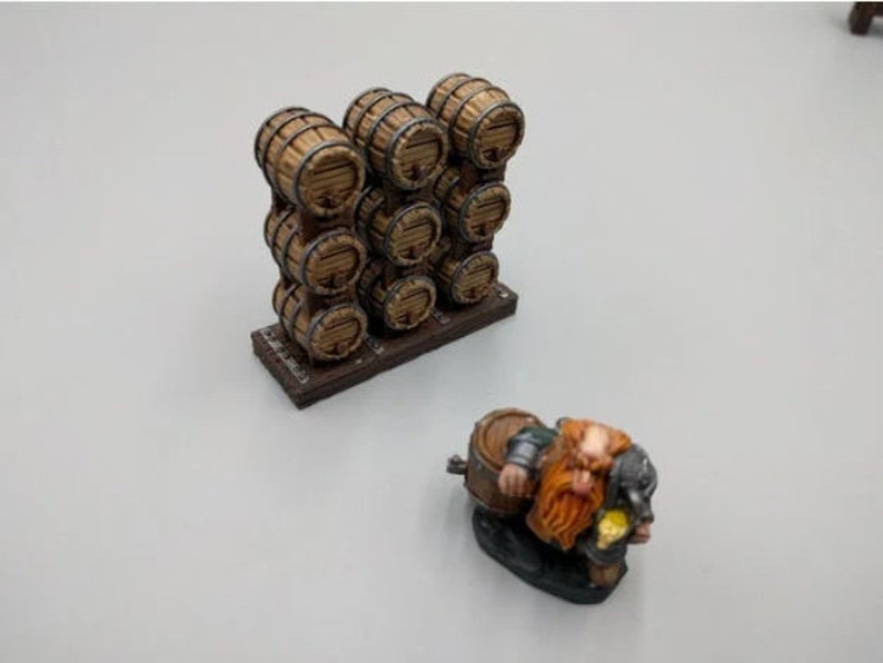 May include: A miniature wooden barrel rack with 10 barrels stacked in a wall formation. A miniature dwarf figure is sitting on a barrel with a mug in hand.