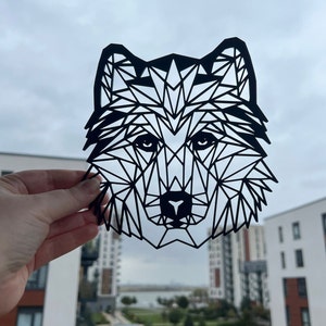 May include: Black geometric wolf silhouette paper cut out. The wolf's head is facing forward with a detailed geometric design.