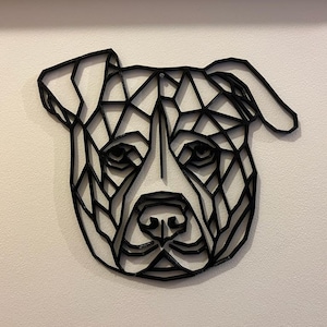 May include: Black and white geometric design of a dog's head, resembling a pit bull terrier, with a triangular pattern.