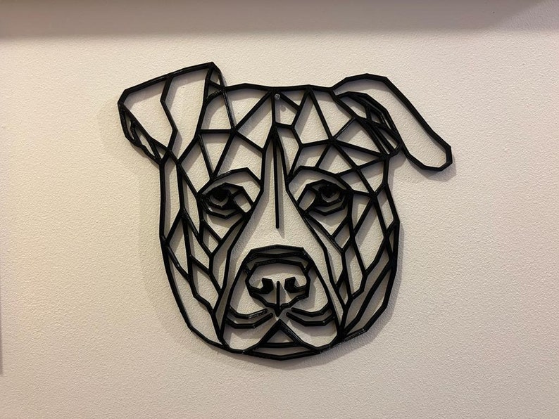 May include: Black and white geometric design of a dog's head, resembling a pit bull terrier, with a triangular pattern.