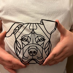 May include: A black and white geometric design of a dog's face. The design is made up of triangles and other geometric shapes.