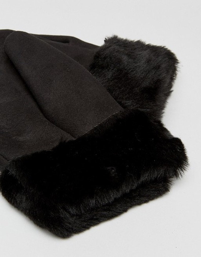 May include: Black faux fur hat with a suede brim and a thick faux fur band around the bottom.