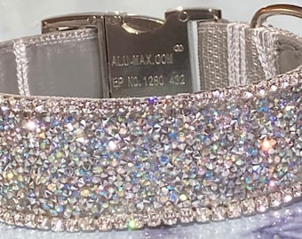 May include: A silver dog collar with a sparkling crystal design. The collar has a metal buckle and a D-ring for leash attachment. The text "ALU-MAX.COM" and "EP NO. 1280 432" are visible on the buckle.
