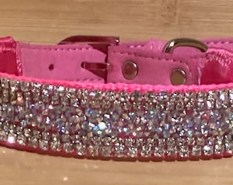 Puede incluir: Un collar de perro de cuero rosa con una fila de brillantes de imitación.