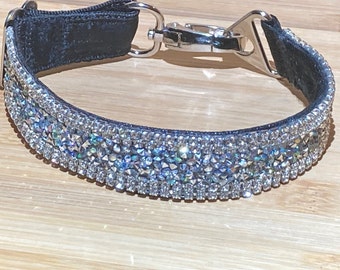 May include: A black velvet dog collar with a silver clasp and rows of clear iridescent rhinestones.