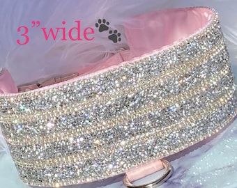 May include: A pink dog collar with a 3" wide band of sparkling rhinestones. The collar has a silver D-ring.