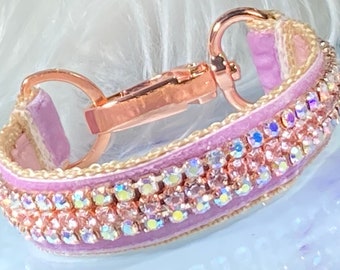 May include: A lavender velvet dog collar with a rose gold metal clasp and two rows of iridescent pink rhinestones.