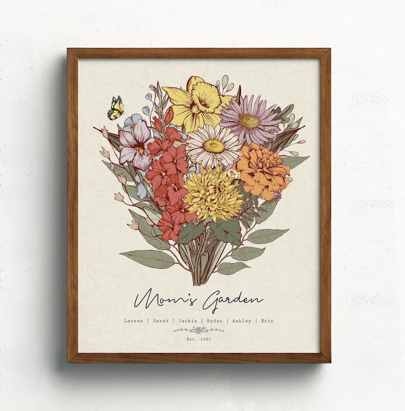 Puede incluir: Una impresi&oacute;n enmarcada con un ramo floral colorido, una mariposa y el texto "Mom's Garden". El ramo incluye flores amarillas, rojas, naranjas y moradas. Los nombres Lauren, Sarah, Jackie, Ryder, Ashley y Eric est&aacute;n listados debajo. Est. 1985.