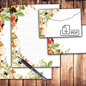 May include: Printable stationery set with a floral design featuring red, orange, and yellow flowers, green leaves, and gold accents. The set includes a letterhead and an envelope. The envelope has a scalloped edge and a download icon with the word "PDF".