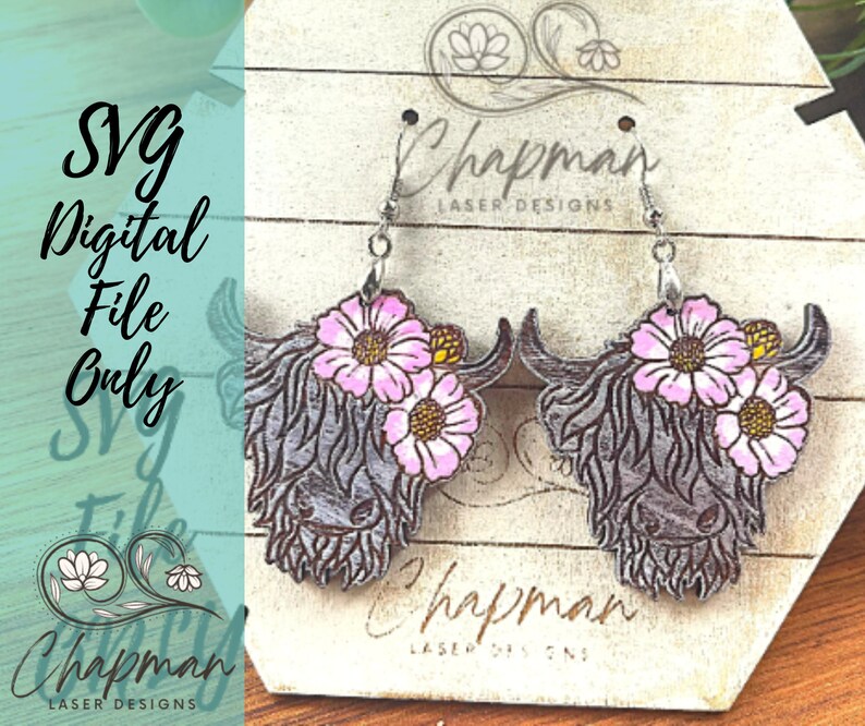 May include: A pair of wooden earrings featuring a Highland cow head with pink flowers. The earrings are on a white background with the text "Chapman Laser Designs".