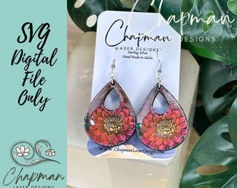 May include: A pair of dangle earrings featuring a floral design. The earrings are made from leather and have a teardrop shape. The flowers are red, yellow, and green. The earrings are suspended from sterling silver hooks. The earrings are handmade in Idaho.