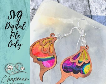 May include: A pair of colourful wooden earrings with a butterfly design. The earrings are made of wood with a colourful, abstract pattern. The earrings are hanging from silver hooks.