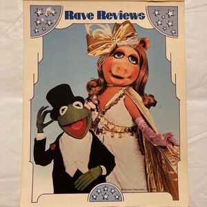 May include: A rectangular notepad featuring the text Rave Reviews at the top. The illustration depicts Kermit the Frog in a black tuxedo and top hat standing next to Miss Piggy, who wears a white gown, gold cape, and a large gold bow in her hair.