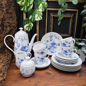 Könnte beinhalten: Ein blaues und weißes Blumen-Tee-Set mit Teekanne, Milchkännchen, Zuckerdose, Tassen, Untertassen und Tellern.