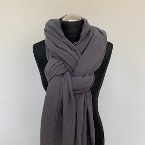 May include: A gray waffle weave cotton scarf with frayed edges. The scarf is draped around a black mannequin.