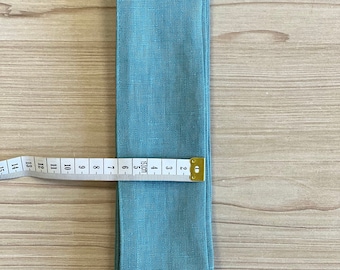 Könnte beinhalten: Ein blaues Leinenband in Teal, das 150 cm lang ist.