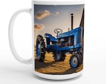 Könnte beinhalten: Weiße Keramiktasse mit einem blauen Oldtimer-Traktor auf einem Feld mit einer Scheune im Hintergrund. Der Traktor hat große Hinterreifen und ein Lenkrad. Der Himmel ist eine Mischung aus Blau und Gelb.