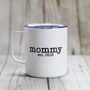 Puede incluir: Taza de viaje de acero inoxidable blanca con tapa azul y texto negro que dice "mommy est. 2020".