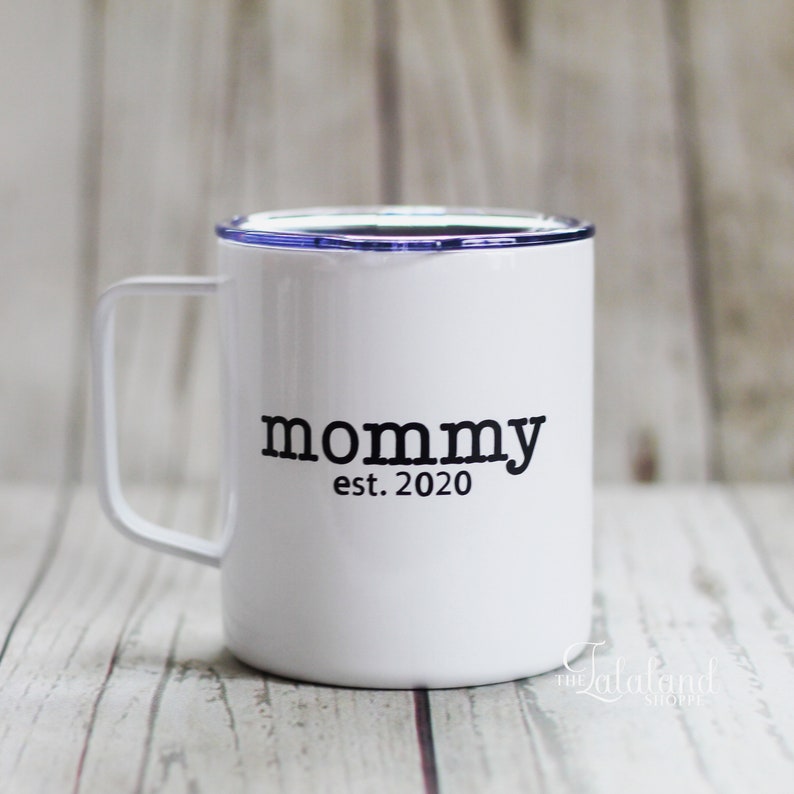 Puede incluir: Taza de viaje de acero inoxidable blanca con tapa azul y texto negro que dice "mommy est. 2020".
