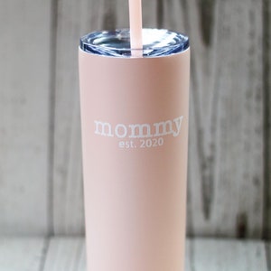 Puede incluir: Un vaso de acero inoxidable rosa con tapa transparente y una pajita. El vaso tiene el texto "mommy est. 2020" impreso en &eacute;l.