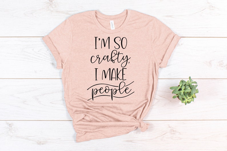 May include: A light pink t-shirt with the text "I'm so crafty. I make people" in black lettering.