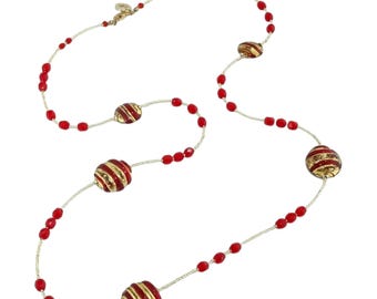 May include: A long necklace featuring red beads and gold-colored, striped, round beads. The necklace has a delicate, silver-colored chain and a gold-colored clasp. The beads are evenly spaced along the chain.