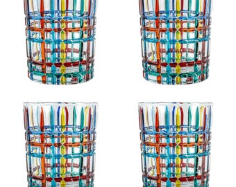 May include: Four clear drinking glasses with a colorful grid pattern. The glasses feature vertical and horizontal lines in red, yellow, blue, and green. The design creates a textured, geometric appearance. The glasses are suitable for serving beverages.