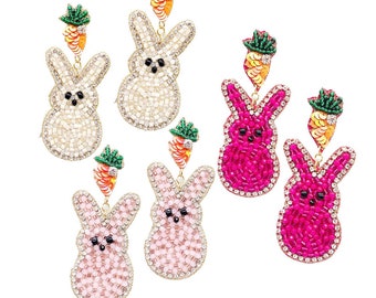 May include: A set of six dangle earrings featuring bunny-shaped charms with carrot accents. The charms are made of white, pink and fuchsia beads.