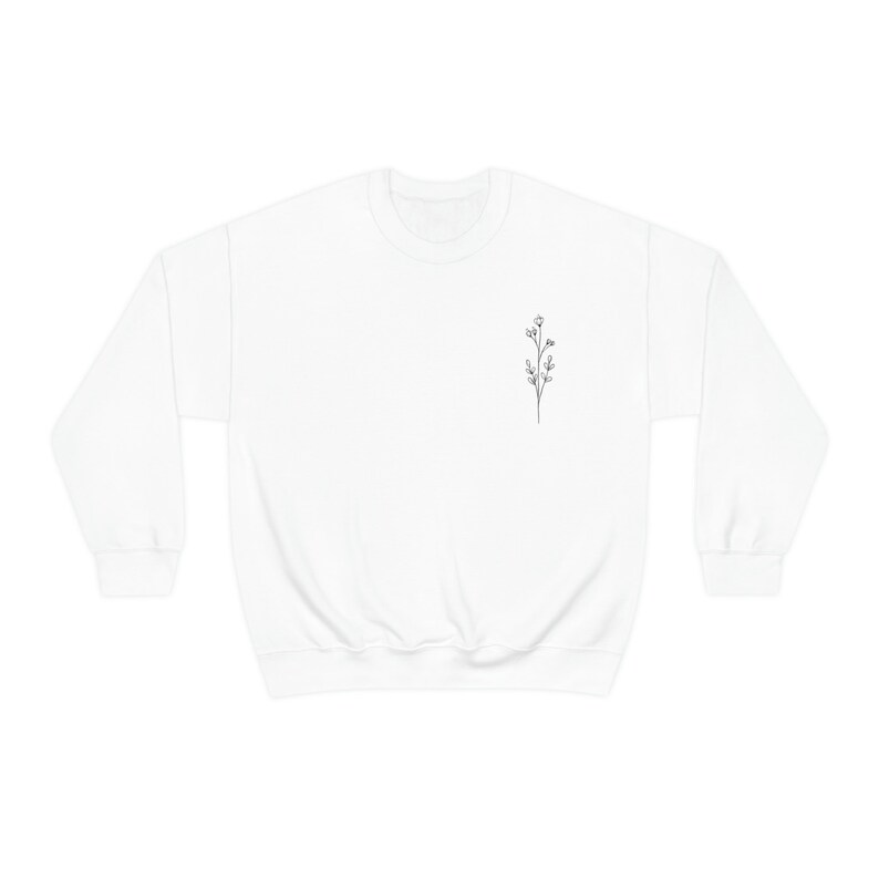May include: White crewneck sweatshirt with a small black line drawing of a flower on the left chest.