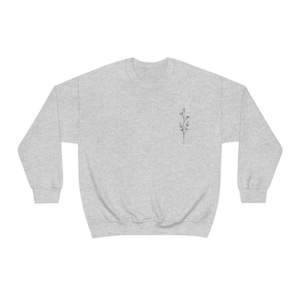 May include: A heather gray sweatshirt with a small, simple line drawing of a flower on the left chest.